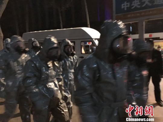 十几名身着防护服的人员头戴面具进入事发地。　胡健 摄